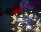 Candles and flowers at a makeshift memorial vigil at night