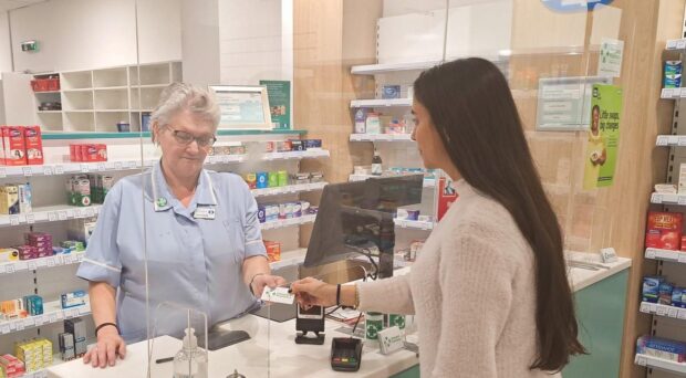 A customer presenting a discreet Lifeguard ‘cue card’ to the pharmacist